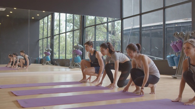一群不同种族的人滚动黑色健身或瑜伽垫之前的瑜伽课视频下载