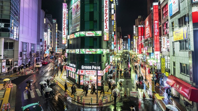 在日本东京新宿，一群人走在霓虹闪烁的购物街上视频素材