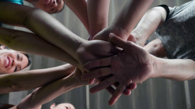 和谐:一群朋友在健身房里双手叠在一起视频下载