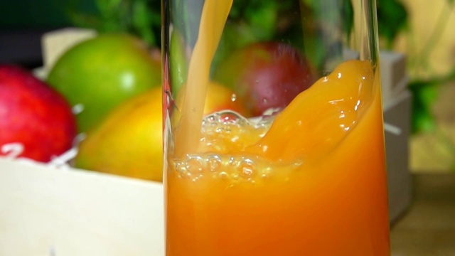 美味的芒果汁倒在一个罐子里，旁边是装满芒果的木箱视频下载