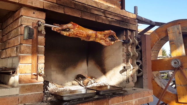 保加利亚烤肉叉上烤羊羔的传统方式。在一家餐厅为顾客烹饪和烤制全羊。视频素材