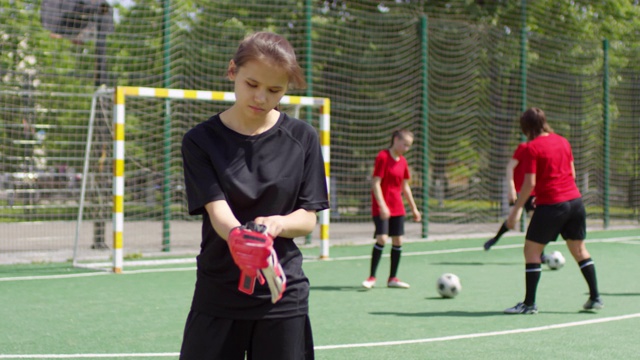 足球训练前戴守门员手套的女孩视频素材