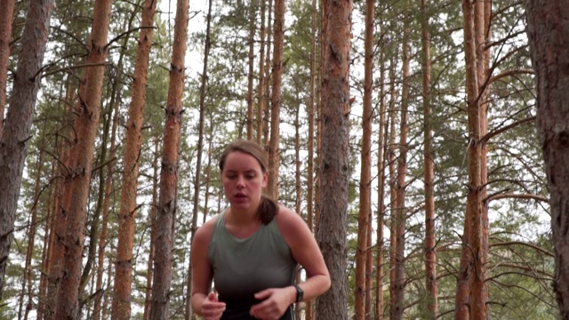 年轻女子在树林里奔跑视频素材