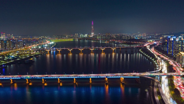从空中俯瞰首尔市中心的天际线，高速公路上的灯光轨迹和横跨汉江的大桥。视频下载