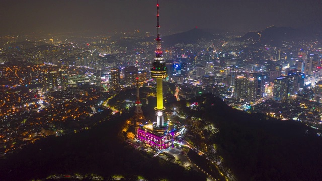 从空中俯瞰韩国首尔市中心的北首尔塔，在夜晚的参孙山上有灯光的痕迹。视频下载