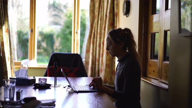 女人坐在家里的办公室里用电脑工作视频素材