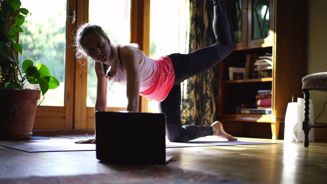 女人在家在瑜伽垫上锻炼视频素材