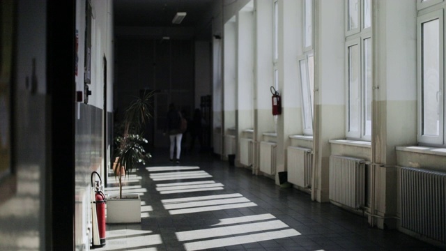 一个学生走在学校空荡荡的大厅里视频素材