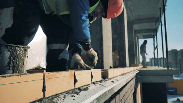 工人们正在工地上砌石。建筑工地的建筑工人。视频素材