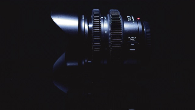 电影镜头被艺术地照亮在黑色的背景上。先进的光学技术。视频素材