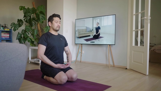 一名日本男子在网上瑜伽课上冥想视频素材