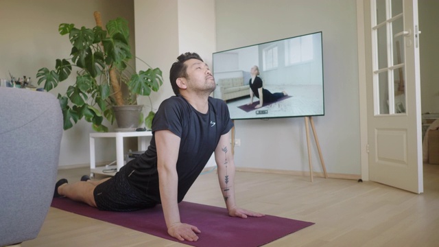 一名日本男子在被隔离期间在线上瑜伽课视频素材