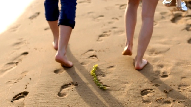 年轻夫妇的腿在沙地上行走视频素材