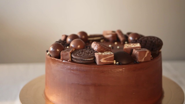 巧克力生日蛋糕和糖果旋转在桌子上视频下载