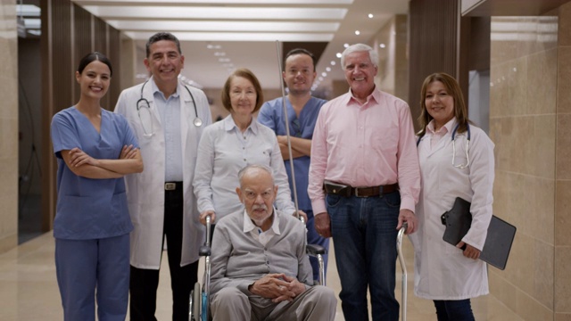 一群老年病人、医生和护士在医院的老年病房对着镜头微笑视频素材
