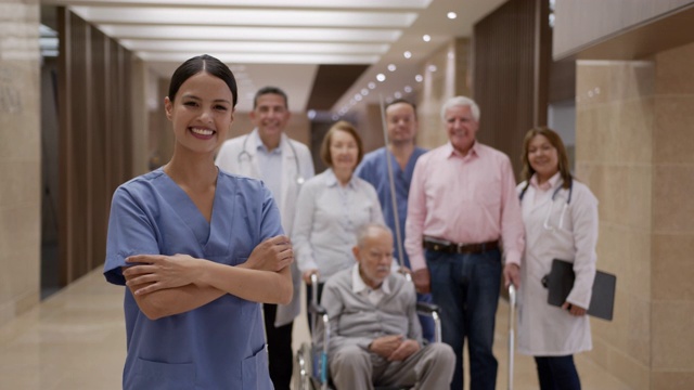 在医院里，美丽的老年护士双臂交叉微笑着走向镜头视频素材
