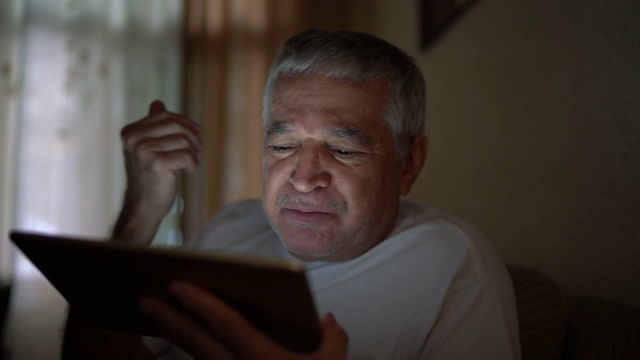 一个老人在家里用平板电脑视频通话视频下载