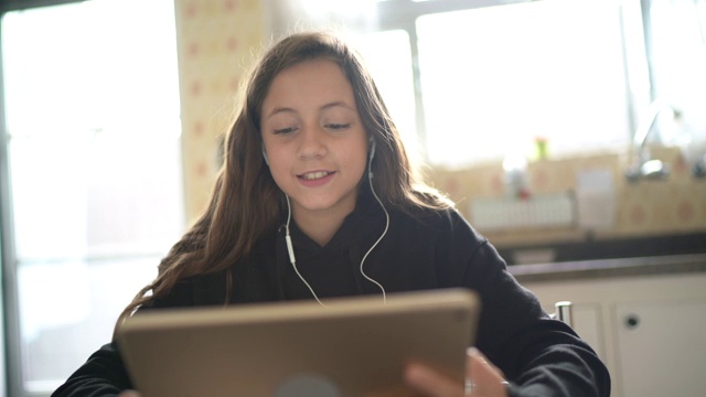 女孩在学习，在家里用平板电脑打视频电话视频下载