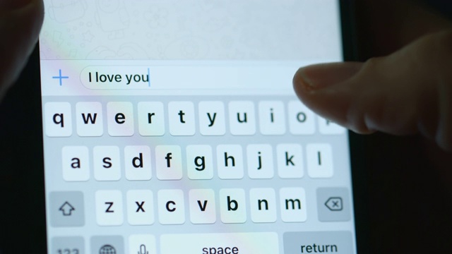 一个用智能手机发送爱情信息的人视频素材