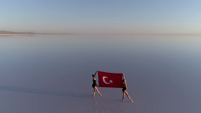 在湖边举着土耳其国旗的芭蕾舞者视频素材