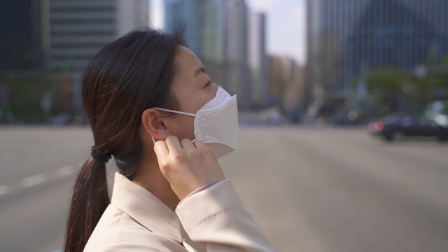 韩国首尔，一名上班族微笑着摘下防护口罩，前往工作场所视频素材