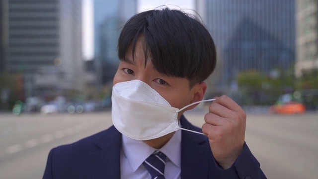 韩国首尔，一名上班族微笑着摘下防护口罩，前往工作场所视频素材