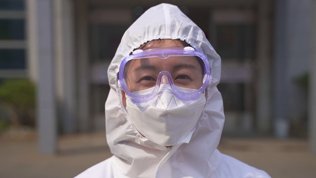 医护人员穿着防护服对医院大楼进行消毒消毒，预防COVID-19视频下载