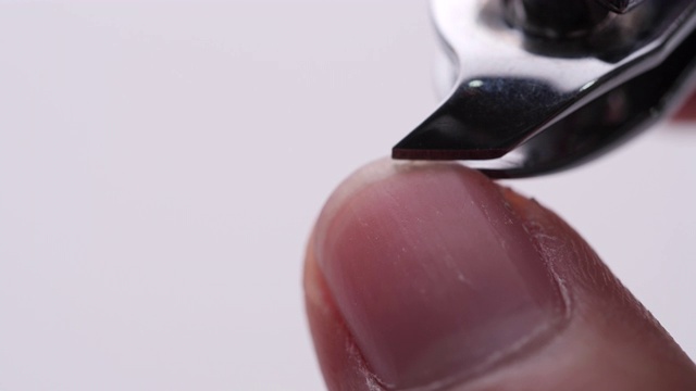 在白色背景上使用指甲钳剪指甲的特写-视频4K视频下载