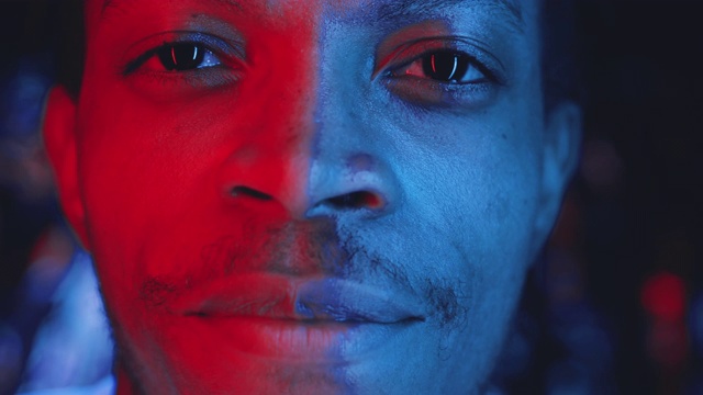 年轻英俊的非裔美国人在彩色霓虹灯的肖像视频素材