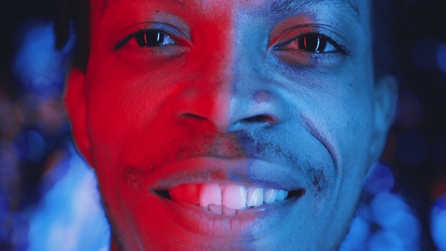 年轻的非裔美国人在霓虹灯下对着照相机微笑视频素材