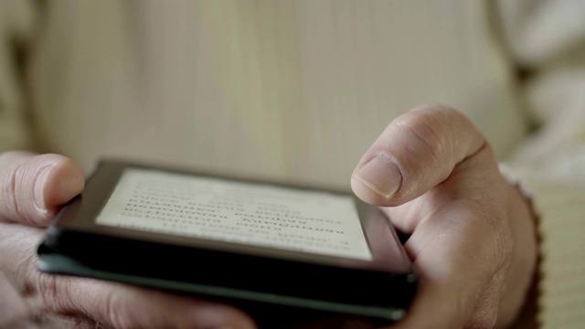 使用电子阅读器平板电脑，男人近距离阅读电子书。软焦点视频素材