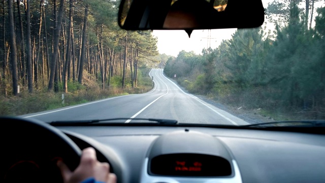 一个男人在乡村的路上开车。乡村林地道路驾驶汽车视频素材