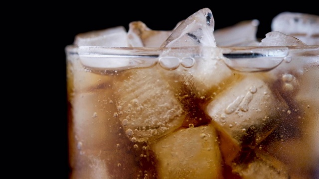 可口可乐在加冰的玻璃杯中冒泡视频素材