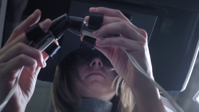 一位女外科医生在虚拟现实中给病人做手术。管理机械臂的手臂。医学新技术，创新。远程治疗癌症患者和感染者视频素材