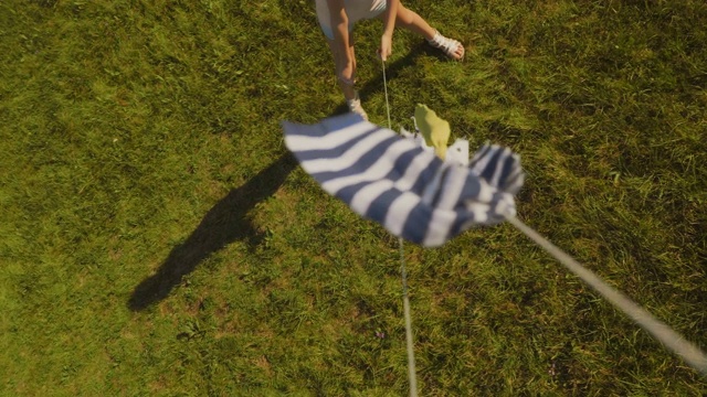 女孩在草地上放风筝。视频素材