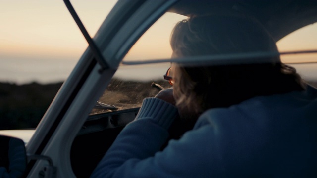 老男人从他的车里看着大海和夕阳视频素材