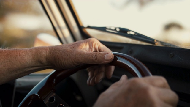 手握方向盘的老者，在乡村道路上行驶视频素材