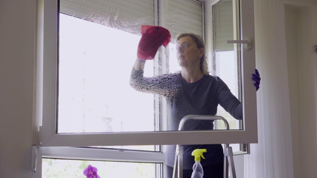 在冠状病毒期间在家清洁窗户的妇女视频素材