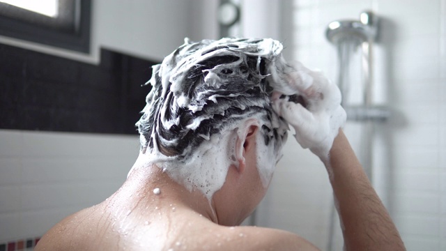 亚洲男人正在浴室里洗头发和沐浴。视频下载
