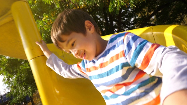 一个孩子从黄色滑梯上滑下来视频下载