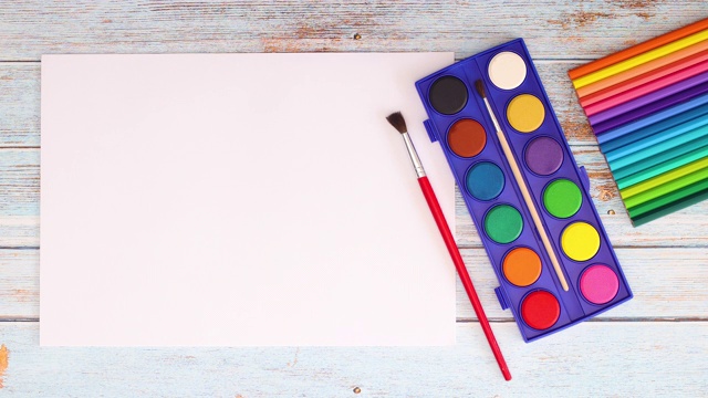 彩色蜡笔出现在桌子上与绘画和艺术用品-停止运动视频下载
