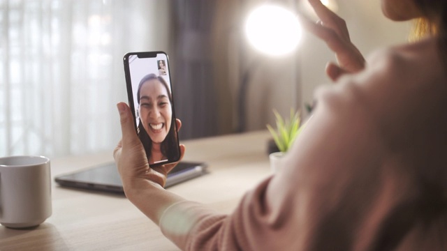 亚洲女性在智能手机上与她的朋友通话，社交距离视频素材