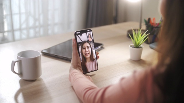 亚洲女性在智能手机上与她的朋友通话，社交距离视频素材