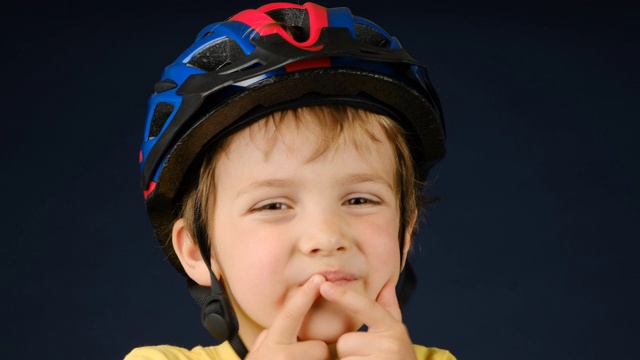 一个小男孩戴着自行车头盔看着摄像机视频素材
