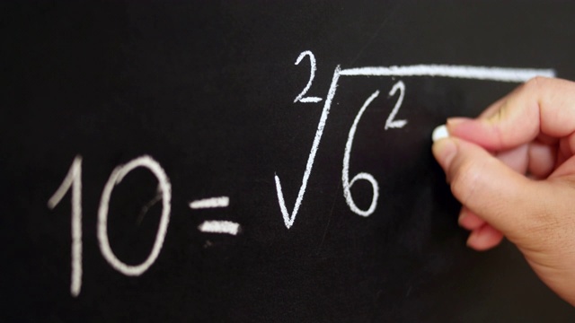 手持粉笔，在黑板上写下复杂复杂的数学公式。视频素材