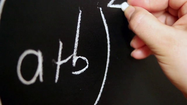 手持粉笔，在黑板上写下复杂复杂的数学公式。视频素材