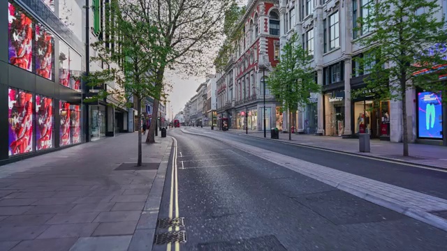 沿着英国伦敦市中心的牛津街(Oxford Street)，黄昏时分人潮稀少，交通繁忙视频下载