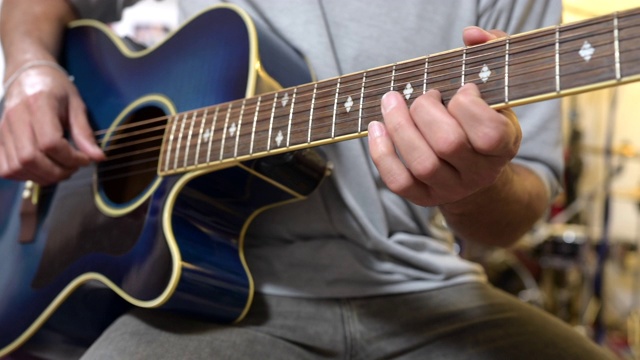 2019冠状病毒病隔离期间，一名年轻人在家弹奏蓝色吉他视频下载