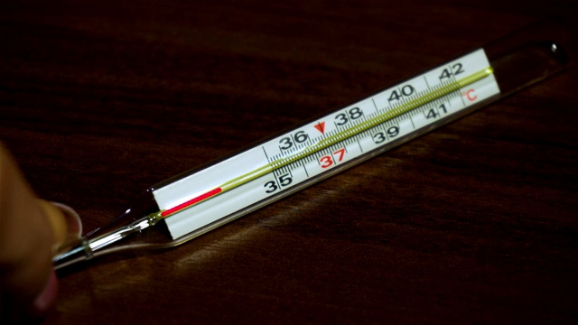 在全球范围内，COVID-19大流行期间，女性手上的医用体温计显示正常温度为36.6摄氏度视频下载