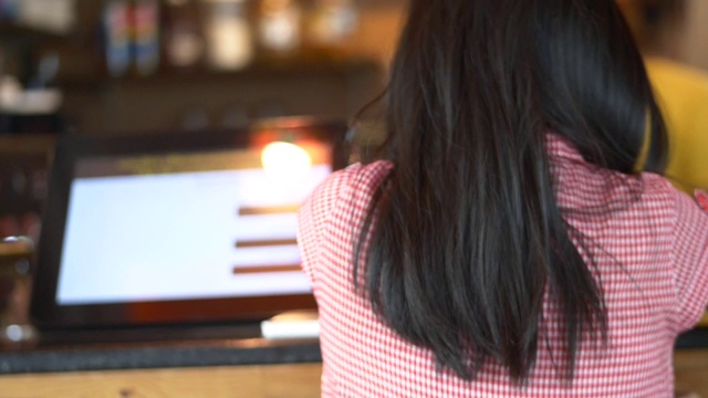 亚洲女孩点菜和等待她的饮料在咖啡馆。视频素材